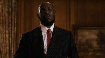 Movie still from “Bessie” (2015), directed by Dee Rees – A man wearing a suit and a red neck tie; Close Up shot, Low angle