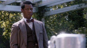 Movie still from “Bessie” (2015), directed by Dee Rees – A man in a suit and bow tie standing in front of a tea pot; Close Up shot, Over the shoulder angle