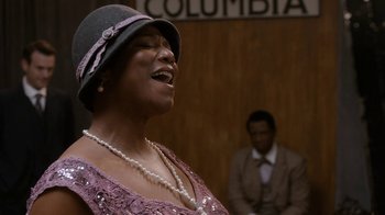 Movie still from “Bessie” (2015), directed by Dee Rees – A woman in a purple dress and hat singing; Close Up shot, Low angle