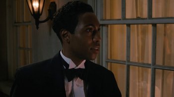Movie still from “Bessie” (2015), directed by Dee Rees – A man in a suit and a bow tie looking to his left; Close Up shot, Over the shoulder angle