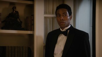 Movie still from “Bessie” (2015), directed by Dee Rees – A man in a tuxedo standing in front of a bookshelf; Close Up shot, Over the shoulder angle