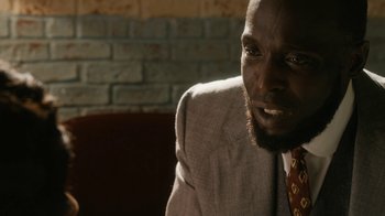 Movie still from “Bessie” (2015), directed by Dee Rees – A person wearing a suit and tie; Close Up shot, Over the shoulder angle