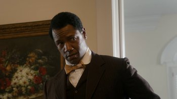 Movie still from “Bessie” (2015), directed by Dee Rees – A man wearing a suit and bow tie; Close Up shot, Low angle