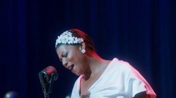 Movie still from “Bessie” (2015), directed by Dee Rees – A woman in a white dress singing on a stage; Close Up shot, Over the shoulder angle