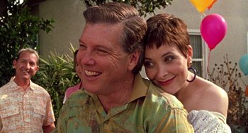 Movie still from “Best in Show” (2000), directed by Christopher Guest – A man and a woman smiling for the camera; Close Up shot, Low angle
