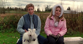 Movie still from “Best in Show” (2000), directed by Christopher Guest – Two women sitting next to each other with a dog; Medium shot, Over the shoulder angle