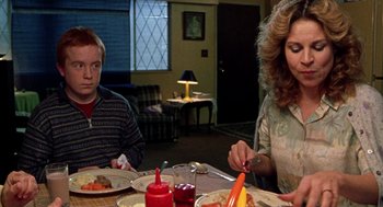 Movie still from “Best in Show” (2000), directed by Christopher Guest – Two people sitting at a dinner table with food; Medium shot, Over the shoulder angle