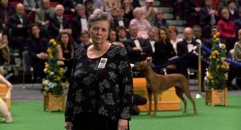 Movie still from “Best in Show” (2000), directed by Christopher Guest – An older woman standing in front of an audience; Close Up shot, High angle