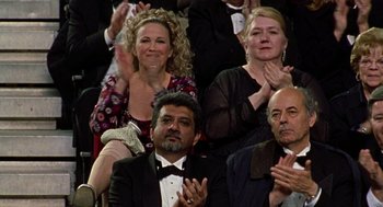 Movie still from “Best in Show” (2000), directed by Christopher Guest – A group of people sitting next to each other clapping; Medium shot, Over the shoulder angle