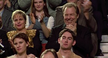Movie still from “Best in Show” (2000), directed by Christopher Guest – A group of people sitting and standing in a room; Medium shot, Over the shoulder angle