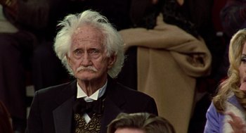 Movie still from “Best in Show” (2000), directed by Christopher Guest – An old man with white hair wearing a suit and bow tie; Close Up shot, High angle