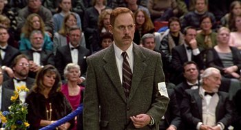 Movie still from “Best in Show” (2000), directed by Christopher Guest – A man standing in front of a crowd of people; Medium shot, Over the shoulder angle