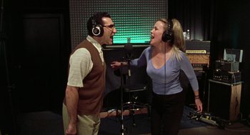 Movie still from “Best in Show” (2000), directed by Christopher Guest – A man and a woman singing in front of a microphone; Medium shot, Low angle