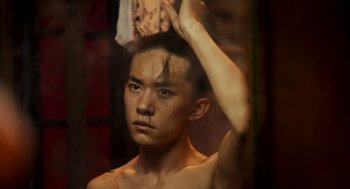 A young man brushing his hair in front of a mirror