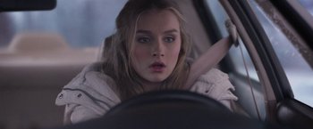 Movie still from “Better Watch Out” (2016), directed by Chris Peckover – A woman is sitting in a car looking at the camera; Close Up shot, Over the shoulder angle