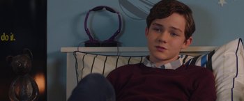 Movie still from “Better Watch Out” (2016), directed by Chris Peckover – A young man sitting on top of a couch; Close Up shot, Over the shoulder angle