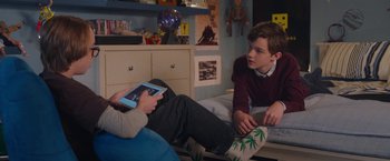 Movie still from “Better Watch Out” (2016), directed by Chris Peckover – Two young men sitting on a bed looking at a tablet; Medium shot, Over the shoulder angle