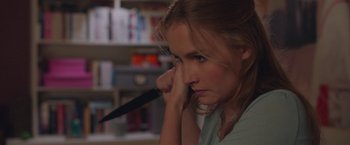 Movie still from “Better Watch Out” (2016), directed by Chris Peckover – A woman holding a knife in her right hand; Close Up shot, Over the shoulder angle