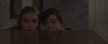 Movie still from “Better Watch Out” (2016), directed by Chris Peckover – A boy and a girl sitting at a table looking at the camera; Close Up shot, Low angle