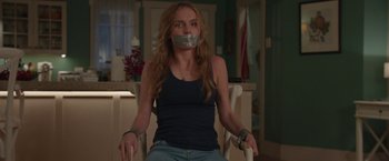 Movie still from “Better Watch Out” (2016), directed by Chris Peckover – A woman with duct tape around her mouth; Medium shot, Over the shoulder angle