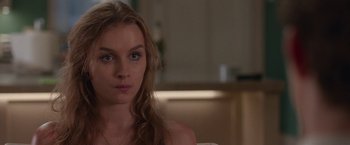 Movie still from “Better Watch Out” (2016), directed by Chris Peckover – A beautiful young woman sitting on top of a couch; Close Up shot, Over the shoulder angle