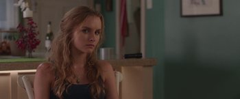 Movie still from “Better Watch Out” (2016), directed by Chris Peckover – A beautiful young woman sitting in a room; Close Up shot, Over the shoulder angle