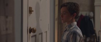 Movie still from “Better Watch Out” (2016), directed by Chris Peckover – A young man standing in front of a door; Close Up shot, Over the shoulder angle