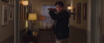 Movie still from “Better Watch Out” (2016), directed by Chris Peckover – A man holding a baseball bat in a room; Medium shot, Over the shoulder angle