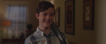 Movie still from “Better Watch Out” (2016), directed by Chris Peckover – A young man holding a hair dryer in his mouth; Medium shot, Over the shoulder angle