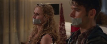 Movie still from “Better Watch Out” (2016), directed by Chris Peckover – A woman with duct tape over her mouth; Close Up shot, Over the shoulder angle