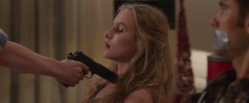 Movie still from “Better Watch Out” (2016), directed by Chris Peckover – A woman holding a gun in front of her face; Close Up shot, Over the shoulder angle