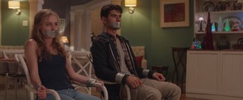 Movie still from “Better Watch Out” (2016), directed by Chris Peckover – A man with duct tape around his mouth sitting in a chair; Medium shot, Over the shoulder angle