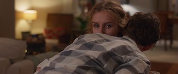 Movie still from “Better Watch Out” (2016), directed by Chris Peckover – A woman hiding under a blanket in a room; Medium shot, Over the shoulder angle