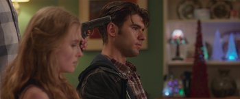 Movie still from “Better Watch Out” (2016), directed by Chris Peckover – A man with a gun in his head and a woman with a gun in his ear; Close Up shot, Over the shoulder angle