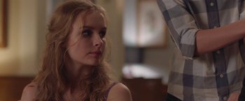 Movie still from “Better Watch Out” (2016), directed by Chris Peckover – A young woman looking into the distance while standing next to a man; Close Up shot, Over the shoulder angle