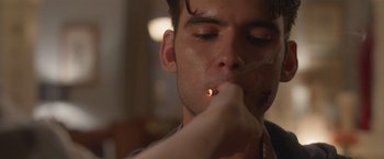 Movie still from “Better Watch Out” (2016), directed by Chris Peckover – A young man lighting a cigarette with a lit cigarette holder; Extreme Close Up shot, Over the shoulder angle