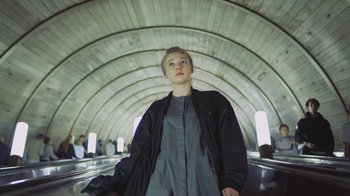 A woman standing in a tunnel looking up at the sky