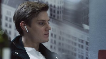 A young man wearing a white ear piece
