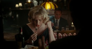 Movie still from “Big Eyes” (2014), directed by Tim Burton – A woman sitting at a table with a fork in her mouth; Medium shot, Over the shoulder angle
