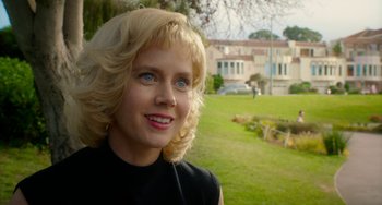 Movie still from “Big Eyes” (2014), directed by Tim Burton – A woman with blonde hair and blue eyes standing in front of a house; Close Up shot, Over the shoulder angle