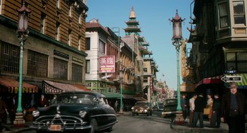 Movie still from “Big Eyes” (2014), directed by Tim Burton – A street scene with cars driving down the road; Extreme Wide shot, High angle
