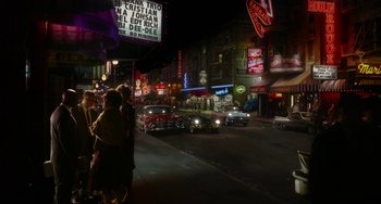 Movie still from “Big Eyes” (2014), directed by Tim Burton – A group of people standing on the side of a street; Extreme Wide shot, High angle