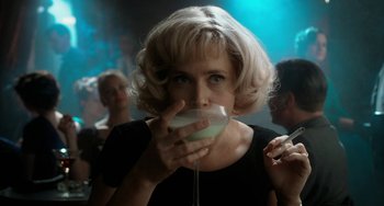 Movie still from “Big Eyes” (2014), directed by Tim Burton – A woman drinking a glass of wine in a dark room; Close Up shot, Over the shoulder angle