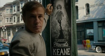 Movie still from “Big Eyes” (2014), directed by Tim Burton – A man standing in front of a poster of a girl; Medium shot, Low angle
