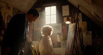 Movie still from “Big Eyes” (2014), directed by Tim Burton – A man and a woman in a room with paintings on the walls; Medium shot, Low angle