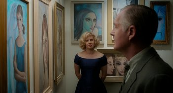 Movie still from “Big Eyes” (2014), directed by Tim Burton – A man and a woman standing next to each other in front of some paintings; Medium shot, Over the shoulder angle