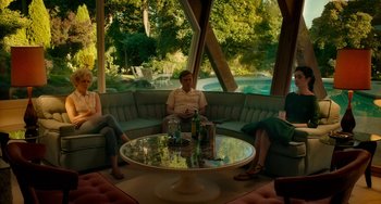 Movie still from “Big Eyes” (2014), directed by Tim Burton – A group of people sitting around a round coffee table; Wide shot, Low angle