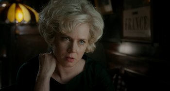 Movie still from “Big Eyes” (2014), directed by Tim Burton – A woman with blonde curly hair is looking at the camera; Close Up shot, Over the shoulder angle
