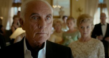 Movie still from “Big Eyes” (2014), directed by Tim Burton – An older man standing in front of a group of people; Close Up shot, Low angle