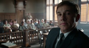 Movie still from “Big Eyes” (2014), directed by Tim Burton – A man in a suit and tie in front of a group of people; Close Up shot, Low angle